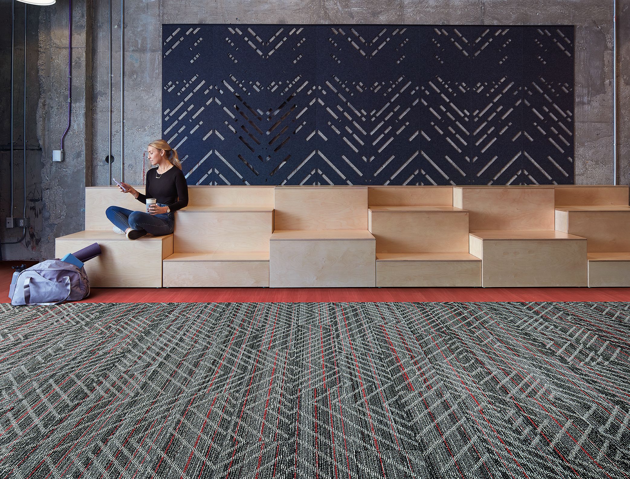 Interface Reflectors plank carpet tile with Studio Set LVT in open area with woman seated on wood risers imagen número 2